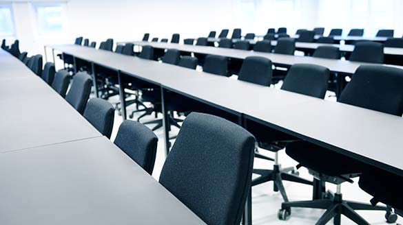 Graduate House inside in a classroom with tables and chairs